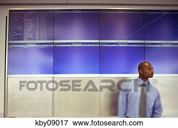 Picture - african businessman 
standing in front 
of departures 
and arrivals board. 
fotosearch - search 
stock photos, 
pictures, images, 
and photo clipart