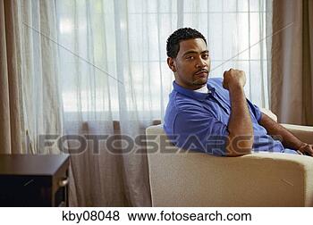 Stock Photo - african man sitting 
in armchair. fotosearch 
- search stock 
photos, pictures, 
images, and photo 
clipart