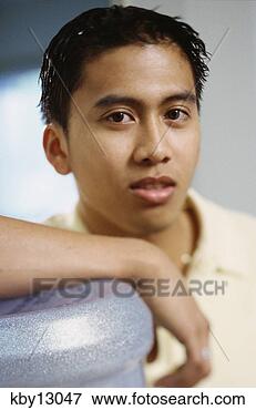 Picture - asian man leaning 
on water cooler. 
fotosearch - search 
stock photos, 
pictures, images, 
and photo clipart