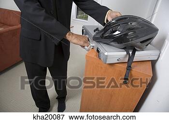 Picture - bicycle helmet 
on briefcase with 
man in background. 
fotosearch - search 
stock photos, 
pictures, images, 
and photo clipart
