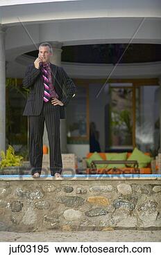 Stock Image - businessman talking 
on cell phone 
at villa. fotosearch 
- search stock 
photos, pictures, 
images, and photo 
clipart