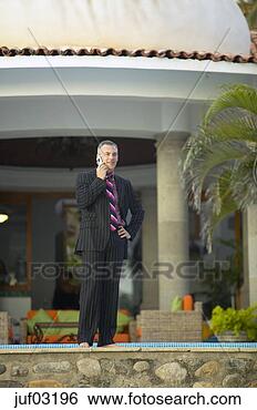 Stock Photo - businessman talking 
on cell phone 
at villa. fotosearch 
- search stock 
photos, pictures, 
images, and photo 
clipart