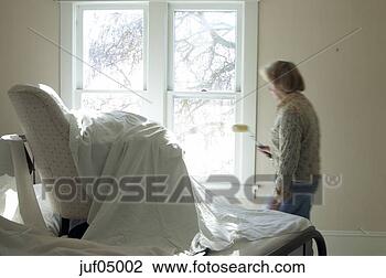 Stock Photo - chair underneath 
sheet as woman 
paints room. fotosearch 
- search stock 
photos, pictures, 
images, and photo 
clipart