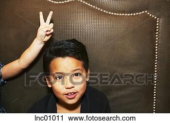 Stock Photography - child making bunny 
ears over boy’s 
head. fotosearch 
- search stock 
photos, pictures, 
images, and photo 
clipart