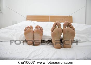 Picture - close up of barefeet, 
couple sleeping 
in bed. fotosearch 
- search stock 
photos, pictures, 
images, and photo 
clipart