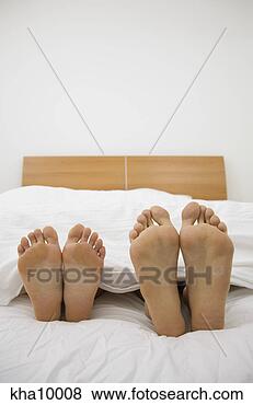 Stock Photo - close up of barefeet, 
couple sleeping 
in bed. fotosearch 
- search stock 
photos, pictures, 
images, and photo 
clipart