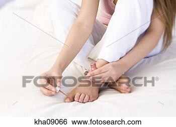 Stock Photo - close up of young 
woman painting 
toe nails on bed. 
fotosearch - search 
stock photos, 
pictures, images, 
and photo clipart