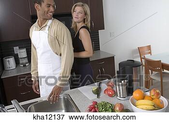 Picture - couple in kitchen, 
woman tying apron. 
fotosearch - search 
stock photos, 
pictures, images, 
and photo clipart