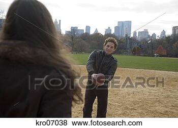 Stock Photo - couple playing 
catch in park 
with view of city 
skyline. fotosearch 
- search stock 
photos, pictures, 
images, and photo 
clipart
