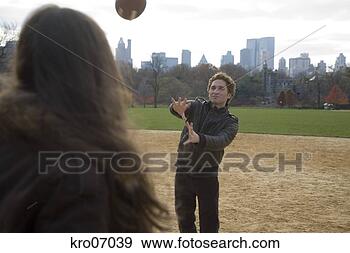 Stock Photograph - couple playing 
catch in park 
with view of city 
skyline. fotosearch 
- search stock 
photos, pictures, 
images, and photo 
clipart
