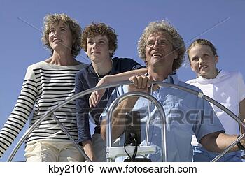 Stock Photo - family looking 
out to sea on 
boat. fotosearch 
- search stock 
photos, pictures, 
images, and photo 
clipart