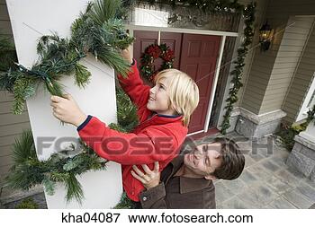 Picture - father helping 
son arrange christmas 
decorations. fotosearch 
- search stock 
photos, pictures, 
images, and photo 
clipart