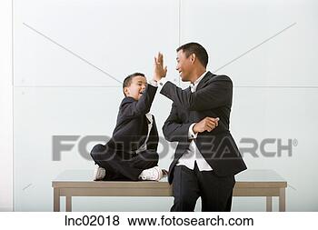 Stock Photo - father and son 
high-fiving. fotosearch 
- search stock 
photos, pictures, 
images, and photo 
clipart