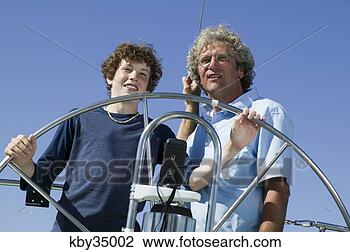 Stock Photo - father teaching 
son to steer boat. 
fotosearch - search 
stock photos, 
pictures, images, 
and photo clipart