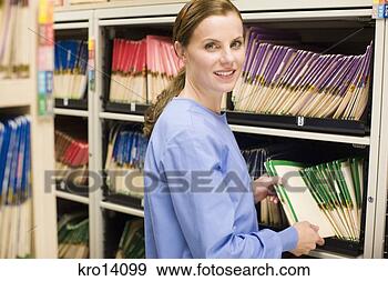 Stock Photograph - female doctor 
taking file off 
shelf. fotosearch 
- search stock 
photos, pictures, 
images, and photo 
clipart