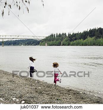Picture - girls chasing 
each other by 
lake. fotosearch 
- search stock 
photos, pictures, 
images, and photo 
clipart