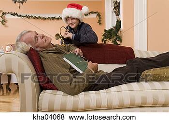Stock Photo - grandson surprising 
sleeping grandfather. 
fotosearch - search 
stock photos, 
pictures, images, 
and photo clipart