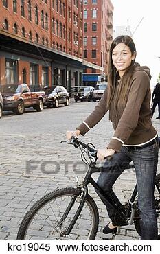 Stock Image - hispanic woman 
standing with 
bicycle. fotosearch 
- search stock 
photos, pictures, 
images, and photo 
clipart