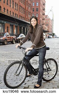 Stock Photo - hispanic woman 
standing with 
bicycle. fotosearch 
- search stock 
photos, pictures, 
images, and photo 
clipart