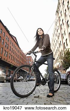 Picture - hispanic woman 
standing with 
bicycle. fotosearch 
- search stock 
photos, pictures, 
images, and photo 
clipart