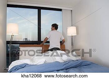 Stock Photo - man on bed looking 
out window. fotosearch 
- search stock 
photos, pictures, 
images, and photo 
clipart