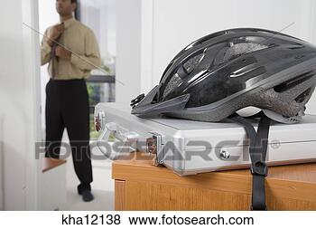 Stock Photo - man dressing for 
work, bike helmet 
and briefcase 
in foreground. 
fotosearch - search 
stock photos, 
pictures, images, 
and photo clipart