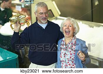 Stock Photography - man holding crab 
as he shops with 
his wife. fotosearch 
- search stock 
photos, pictures, 
images, and photo 
clipart
