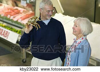 Stock Photo - man holding crab 
as he shops with 
his wife. fotosearch 
- search stock 
photos, pictures, 
images, and photo 
clipart
