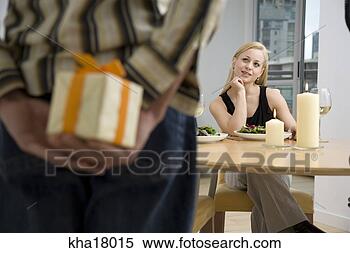 Stock Image - man holding surprise 
gift for girlfriend. 
fotosearch - search 
stock photos, 
pictures, images, 
and photo clipart
