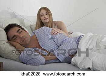 Stock Photo - man sleeping in 
bed with wife 
leaning over his 
shoulder. fotosearch 
- search stock 
photos, pictures, 
images, and photo 
clipart