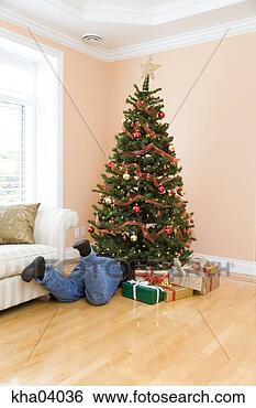 Stock Photo - man underneath 
christmas tree. 
fotosearch - search 
stock photos, 
pictures, images, 
and photo clipart
