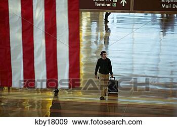 Stock Photograph - man walking through 
airport, reagan 
international 
airport. fotosearch 
- search stock 
photos, pictures, 
images, and photo 
clipart