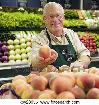 Stock Image - mature grocery 
clerk working 
in produce aisle 
of grocery store. 
fotosearch - search 
stock photos, 
pictures, images, 
and photo clipart