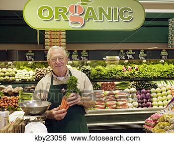 Stock Photo - mature grocery 
clerk working 
in organic produce 
aisle of grocery 
store. fotosearch 
- search stock 
photos, pictures, 
images, and photo 
clipart