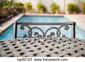 Stock Photo - metal backyard 
furniture by swimming 
pool. fotosearch 
- search stock 
photos, pictures, 
images, and photo 
clipart