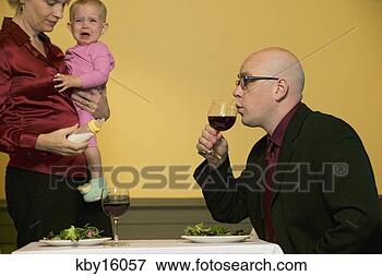 Picture - mother holding 
crying baby as 
husband sips wine. 
fotosearch - search 
stock photos, 
pictures, images, 
and photo clipart