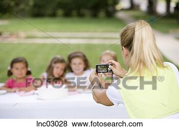 Stock Photo - mother taking 
photograph of 
daughter’s birthday 
party. fotosearch 
- search stock 
photos, pictures, 
images, and photo 
clipart