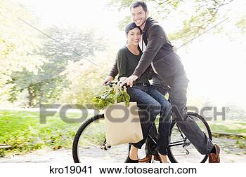 Stock Photography - multi-ethnic couple 
riding same bicycle. 
fotosearch - search 
stock photos, 
pictures, images, 
and photo clipart