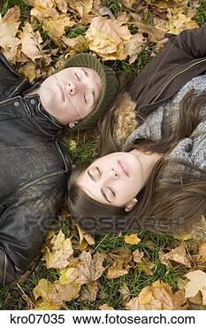 Stock Image - overhead view 
of couple lying 
in autumn leaves. 
fotosearch - search 
stock photos, 
pictures, images, 
and photo clipart