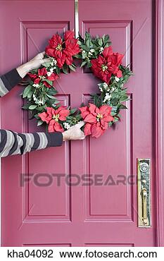 Stock Photo - person hanging 
christmas wreath. 
fotosearch - search 
stock photos, 
pictures, images, 
and photo clipart