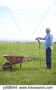 Stock Photo - senior man using 
wheelbarrow and 
shovel. fotosearch 
- search stock 
photos, pictures, 
images, and photo 
clipart