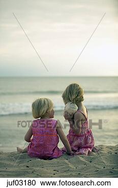 Stock Photography - sisters listening 
to seashell at 
beach. fotosearch 
- search stock 
photos, pictures, 
images, and photo 
clipart
