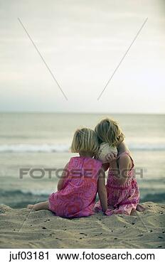 Stock Photography - sisters listening 
to seashell at 
beach. fotosearch 
- search stock 
photos, pictures, 
images, and photo 
clipart
