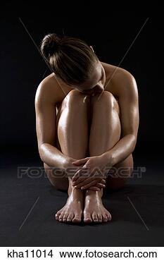 Stock Photo - studio shot of 
young woman hugging 
knees. fotosearch 
- search stock 
photos, pictures, 
images, and photo 
clipart
