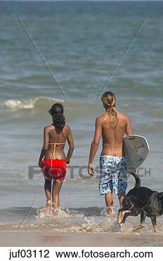 Stock Photo - surfer and woman 
going out to swim. 
fotosearch - search 
stock photos, 
pictures, images, 
and photo clipart