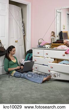 Stock Photograph - teenage girl using 
laptop in messy 
room. fotosearch 
- search stock 
photos, pictures, 
images, and photo 
clipart