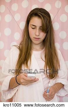 Stock Image - teenage girl using 
her cell phone 
in bathroom. fotosearch 
- search stock 
photos, pictures, 
images, and photo 
clipart