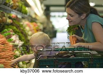Stock Photo - toddler reaching 
for carrots in 
supermarket. fotosearch 
- search stock 
photos, pictures, 
images, and photo 
clipart