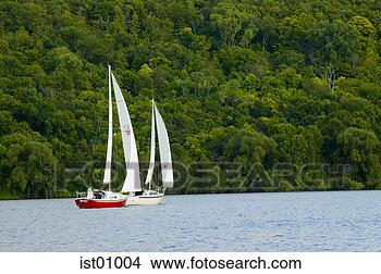 Stock Photo - two sailboats 
sailing along 
coastline. fotosearch 
- search stock 
photos, pictures, 
images, and photo 
clipart