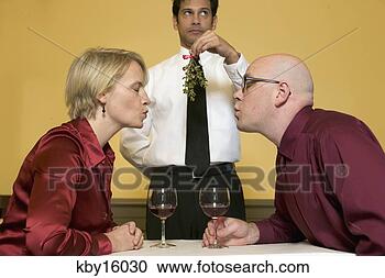Stock Photography - waiter holding 
mistletoe for 
kissing couple. 
fotosearch - search 
stock photos, 
pictures, images, 
and photo clipart